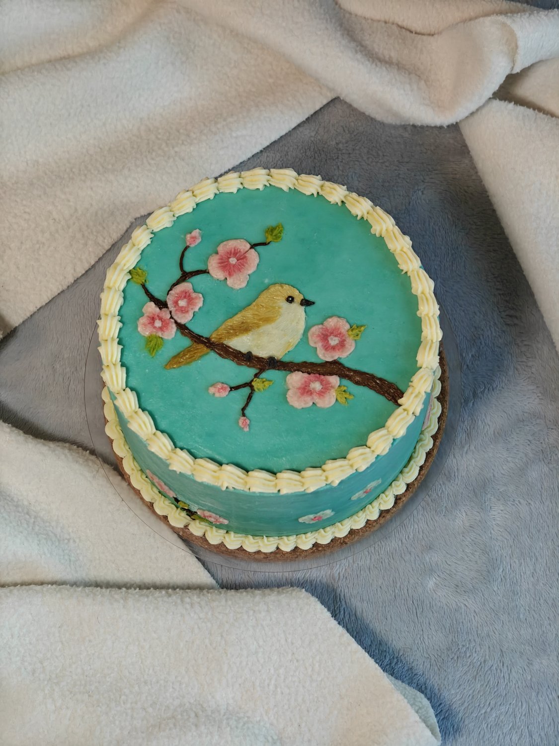 Hand-painted bird on turquoise two-tier cake